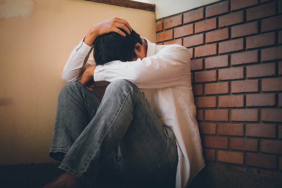 Depressed Man Sitting Head in Hands on the Stairs in Building. W